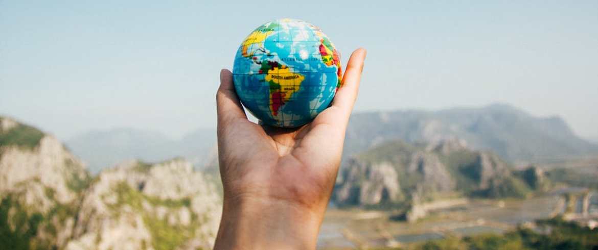 la miniature d'un globe terrestre dans la main d'une personne
